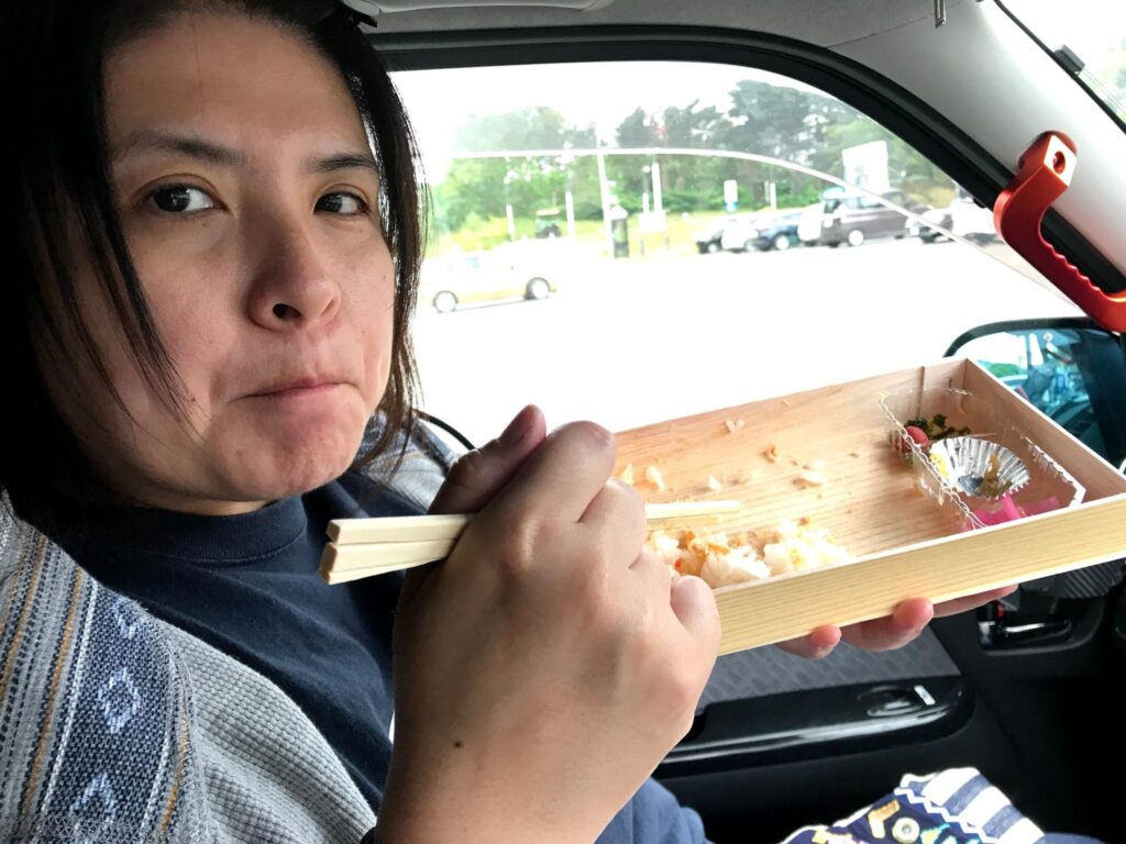 車内で北海道のかに釜飯弁当を楽しむ様子を写した写真