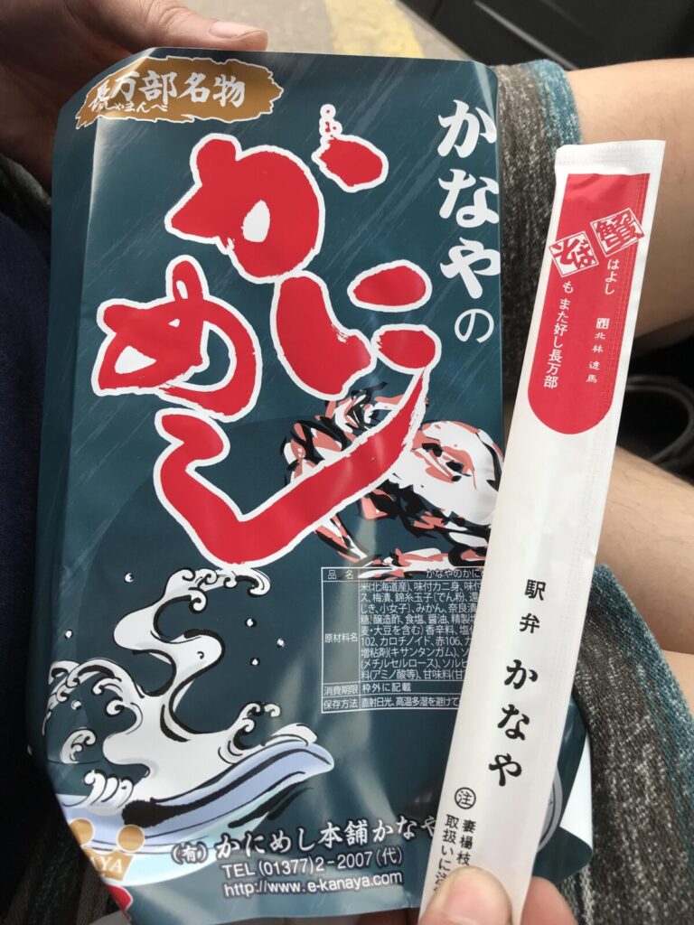 駅弁「かなやのかにめし」のパッケージ写真。赤い大きな文字が印象的