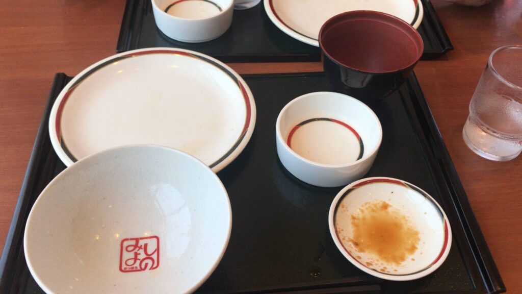 食べ終わった定食の空のお皿とみよしののロゴ入り茶碗