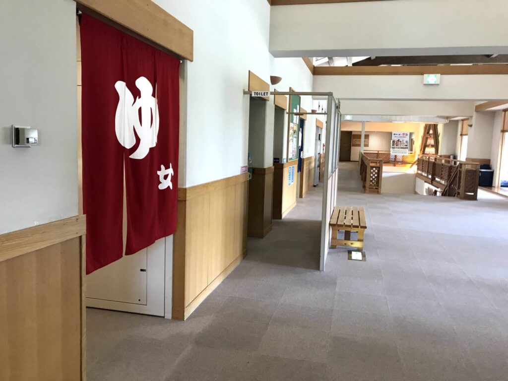 花神楽の女湯入口、赤い暖簾に「ゆ」の文字が見える