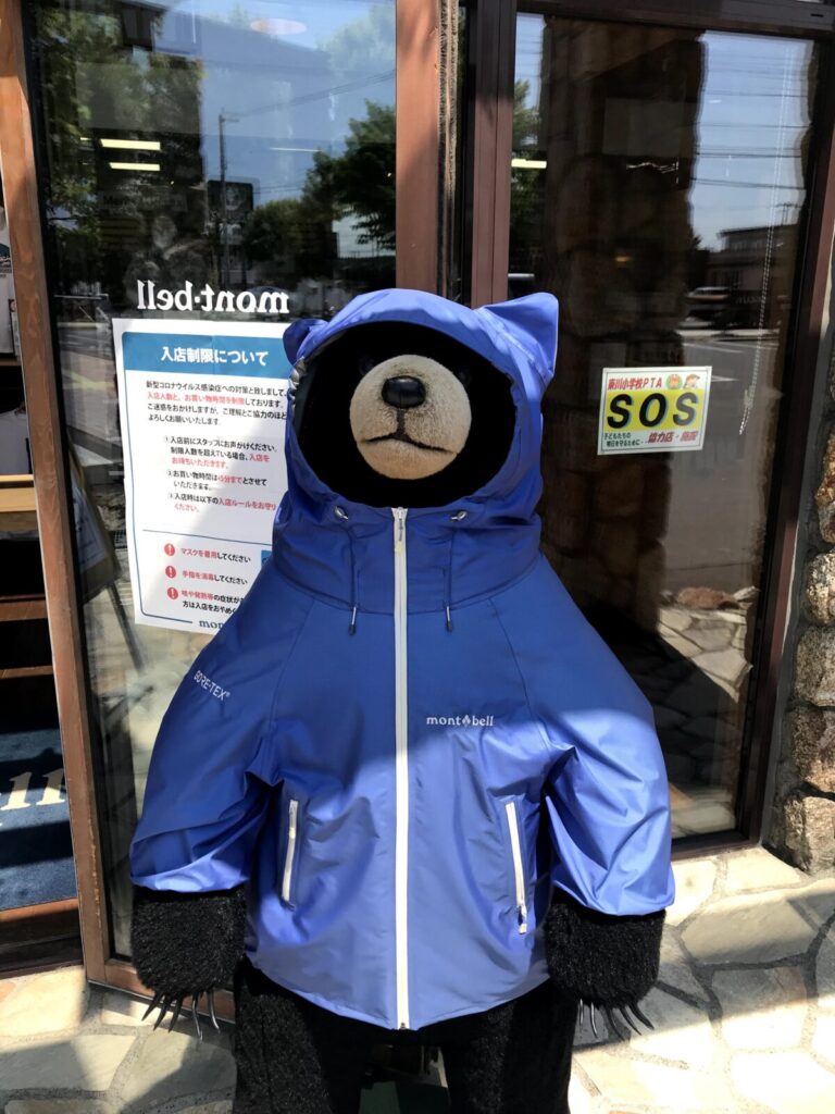 モンベル店舗前に立つ青いレインウェアを着たくまの人形