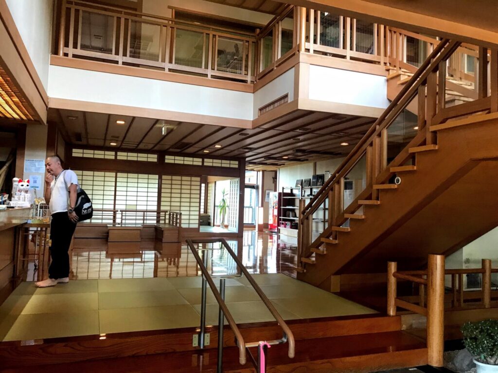 畳のロビーと木の階段がある岩内温泉の館内