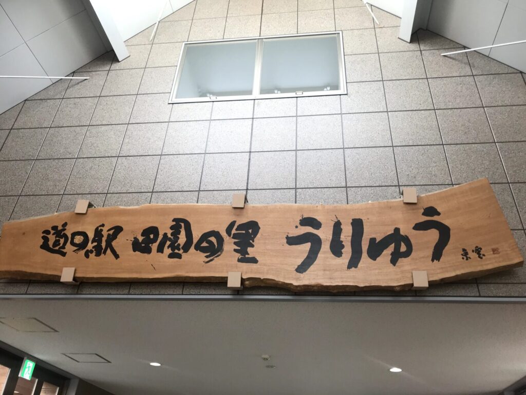 道の駅田園の里うりゅうの木製看板に筆文字で書かれた施設名