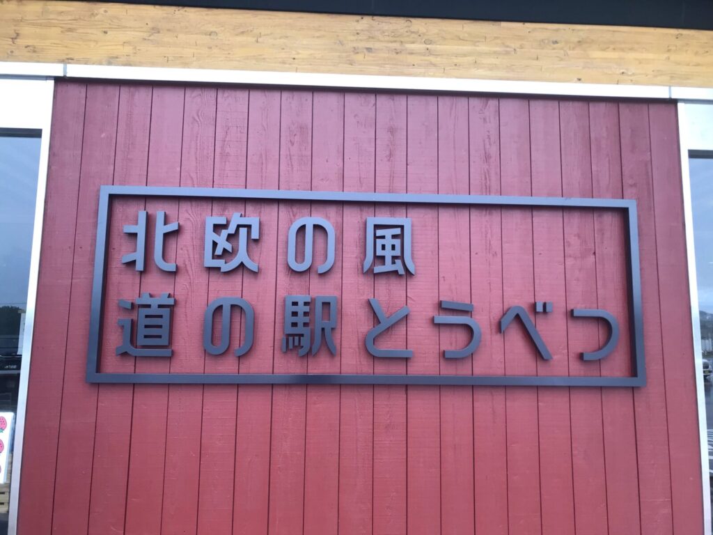 北欧の風 道の駅とうべつの外観にある赤い木壁と案内看板