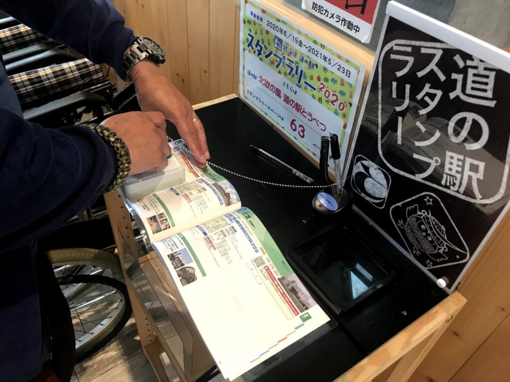 道の駅スタンプラリーの押印コーナーでスタンプを押す様子