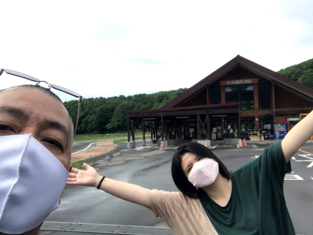 道の駅あかいがわの前でポーズをとる夫婦