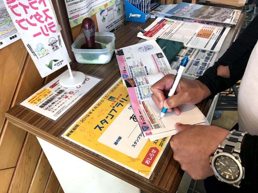 道の駅あっさぶでスタンプラリー帳に記入する様子