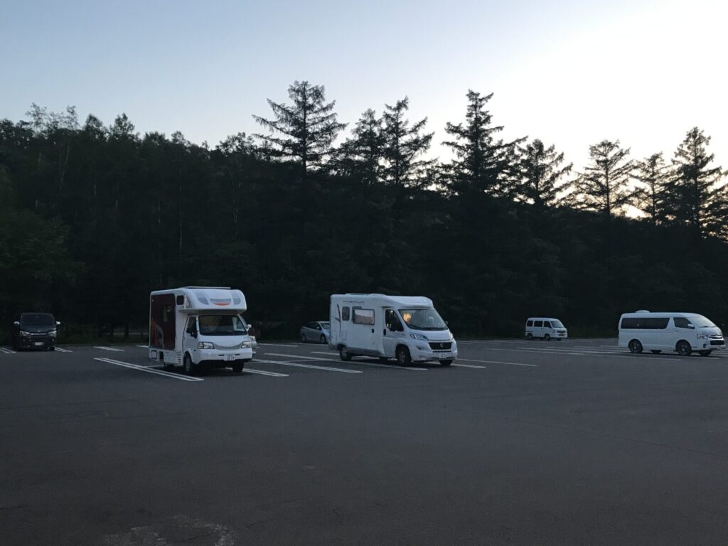 道の駅美瑛の駐車場に停車する複数のキャンピングカーとバン