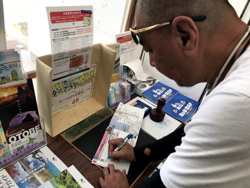 道の駅ルート229元和台でスタンプ帳に記入する男性