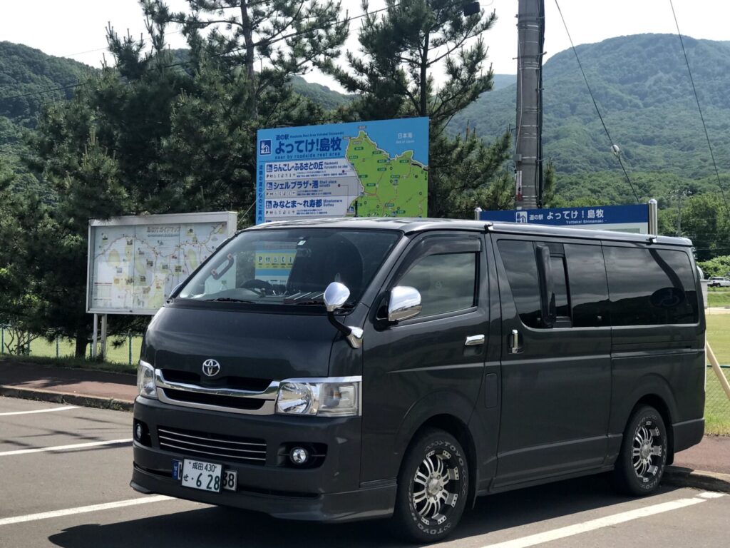 道の駅駐車場に停められた車とバックの案内看板