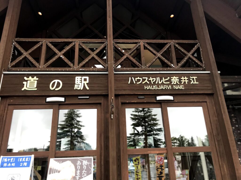 木のぬくもりある建物に「道の駅 ハウスヤルビ奈井江」と書かれた正面看板のクローズアップ