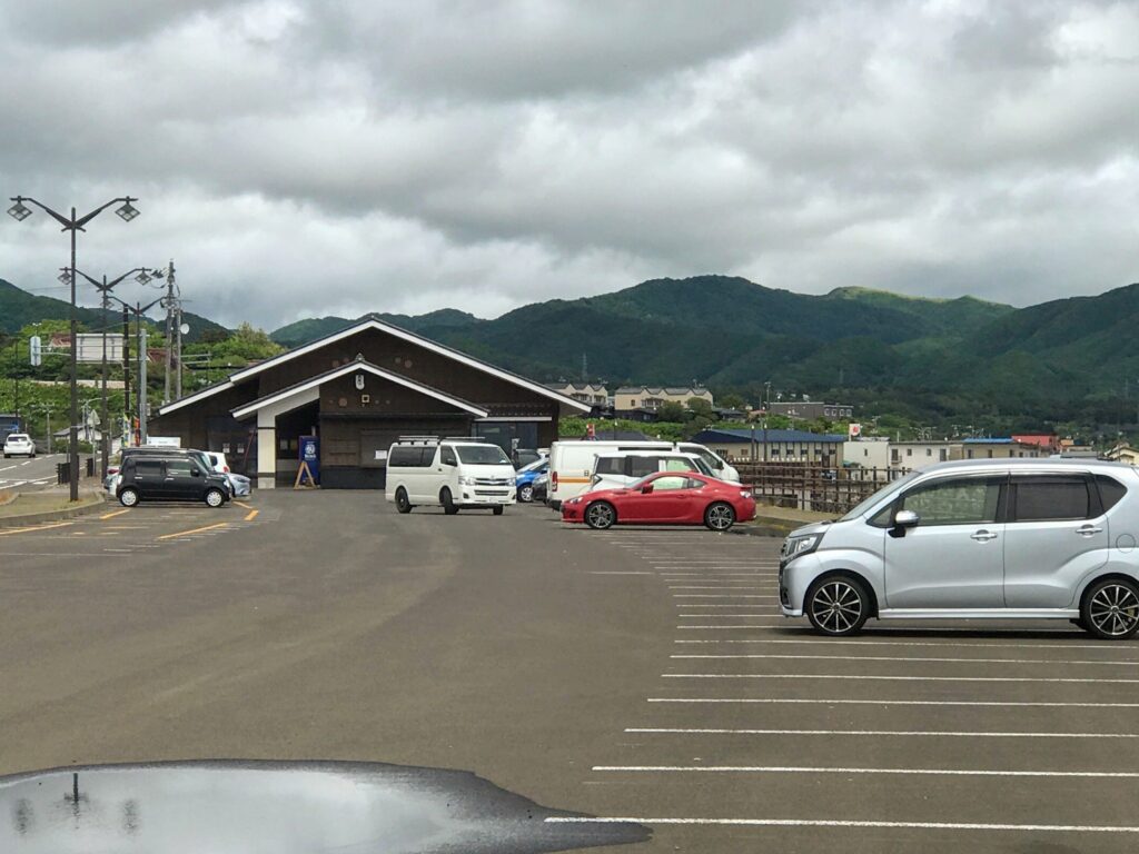 道の駅松前の駐車場と建物、背後に広がる緑の山々