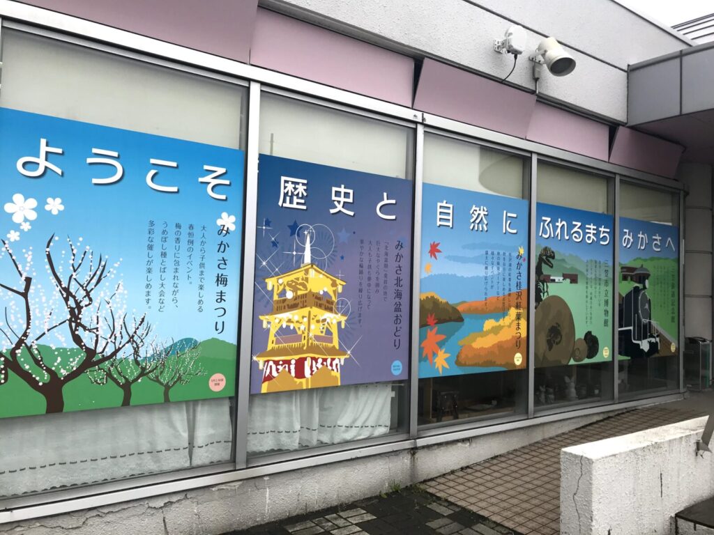 窓一面に貼られた三笠市の観光案内ポスター