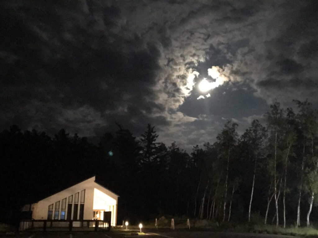雲間から差し込む月明かりと道の駅「森のディスカバリー」の幻想的な夜景