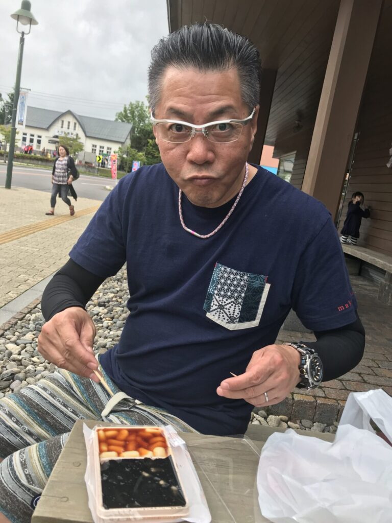 「沼の家」のだんごを食べる男性。だんごはたれとごま味の2種