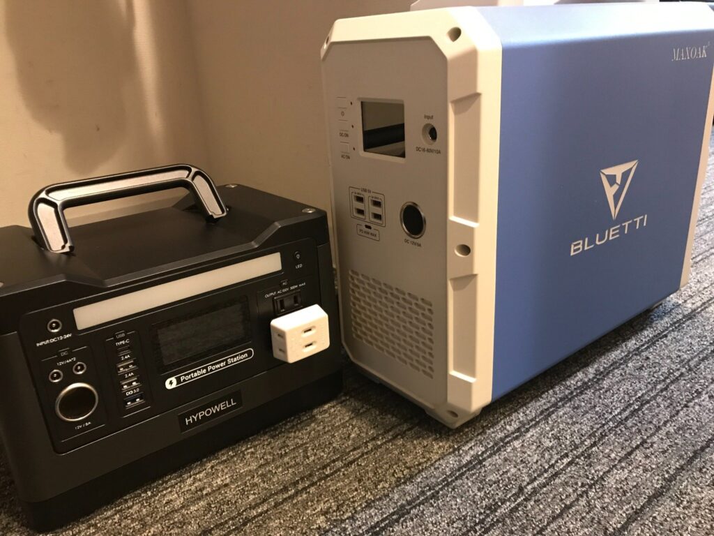 HYPOWELLとBLUETTIのポータブル電源をホテルの室内で充電している様子。カーペットの床に設置された状態。