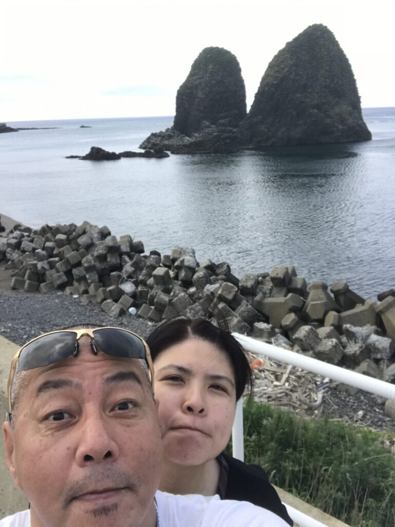 奇岩を背景にした笑顔の記念写真