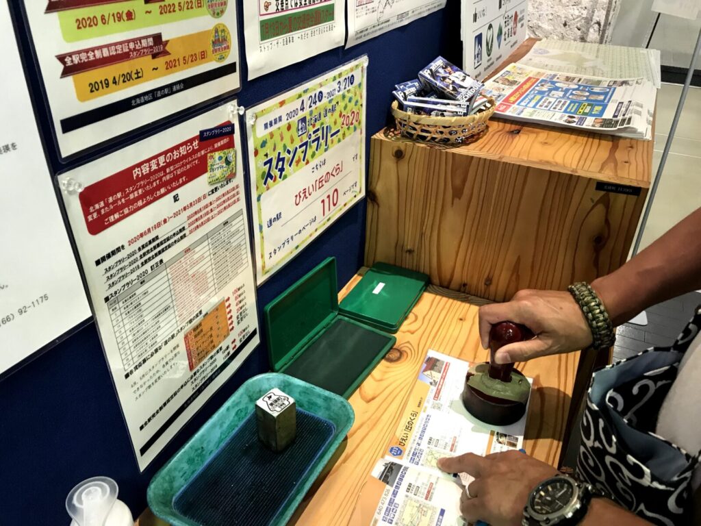 北海道美瑛の道の駅『丘のくら』でスタンプを押す様子