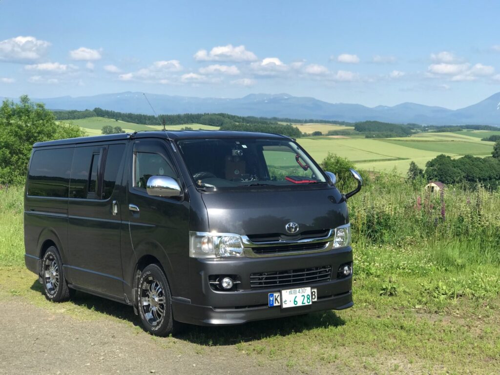 北海道美瑛町の丘に停車するハイエースの車中泊仕様車