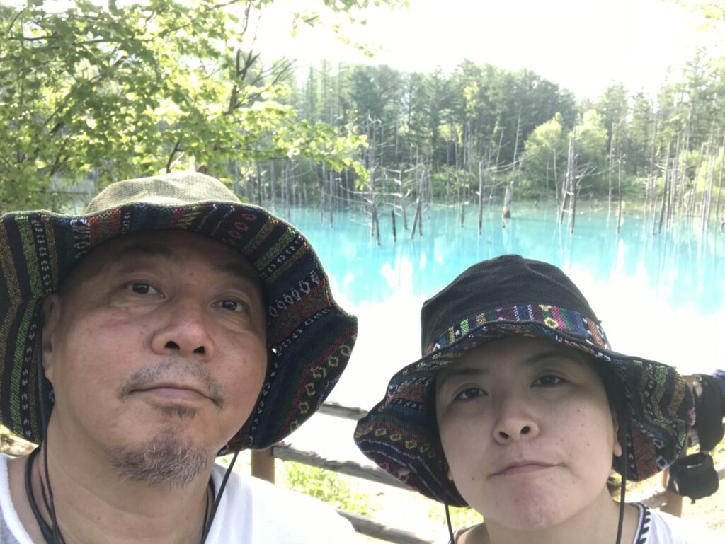 青い池を背景に、仲良く並ぶくま夫婦のツーショット