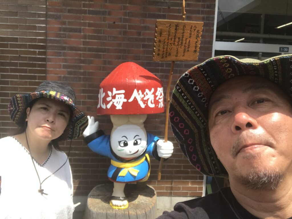 北海道へそ祭りキャラクターと記念写真を撮る二人