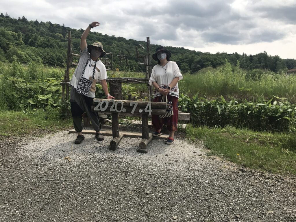 自由の森の記念ベンチで撮影された男女の写真。看板に「2020.7.4」の日付が書かれている。