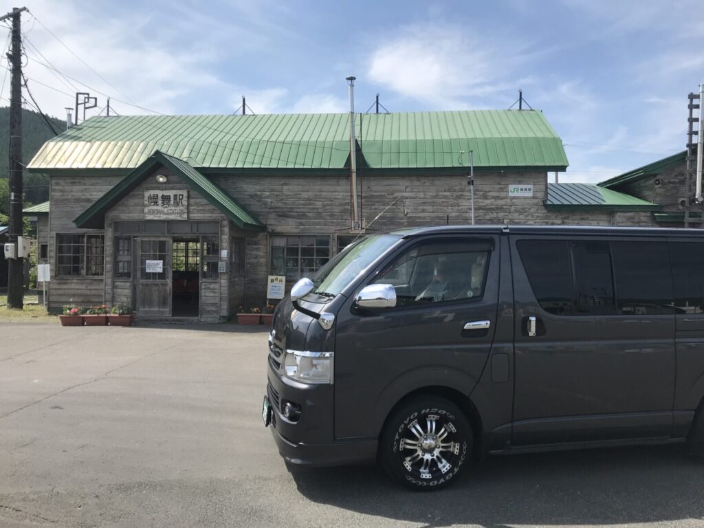 幌舞駅の前に停車したハイエースと駅舎の風景