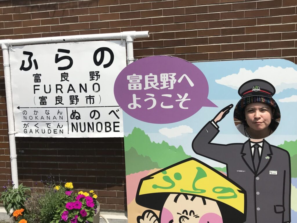 富良野駅の顔出しパネルで記念撮影する女性