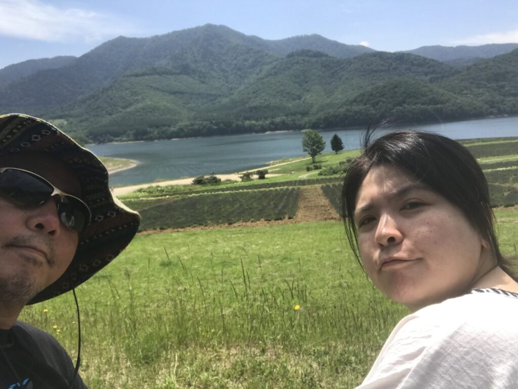 かなやま湖とラベンダー畑を背景にした夫婦の自撮り写真