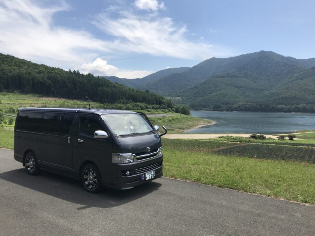 かなやま湖を背景にハイエースが停車している風景