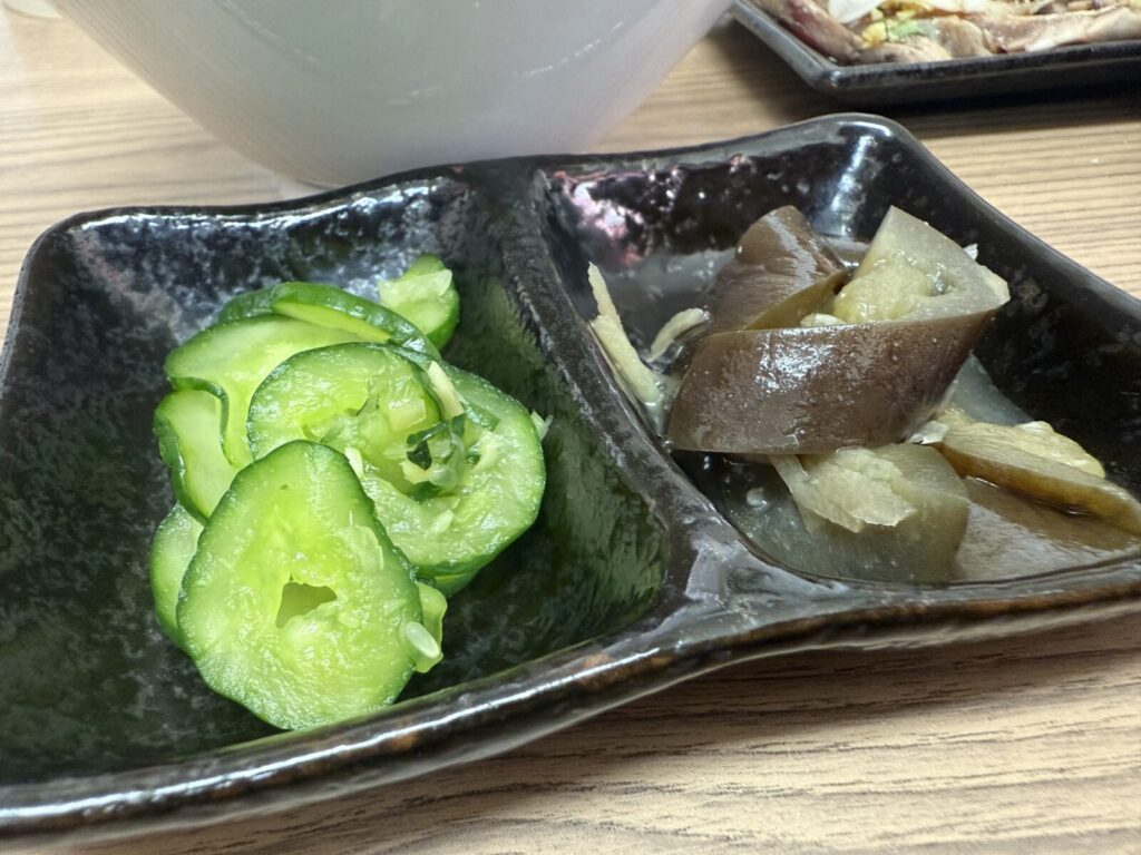 朝定食に添えられたキュウリの浅漬けとナスの煮物
