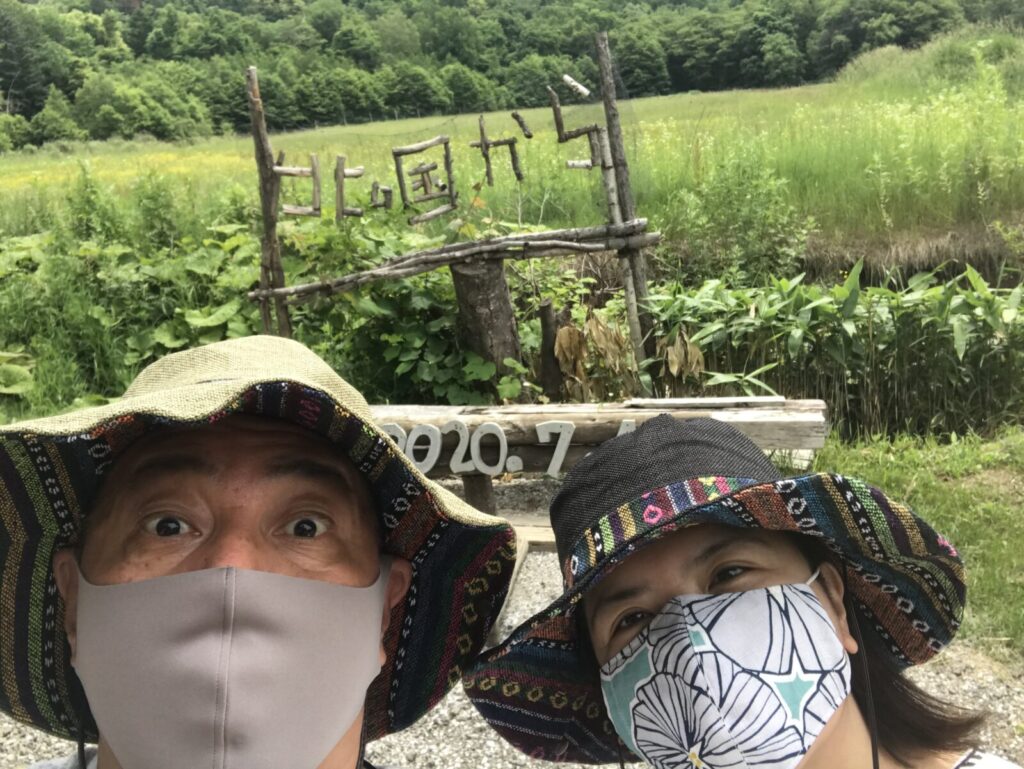北の国からの看板前で記念撮影をする帽子姿の夫婦
