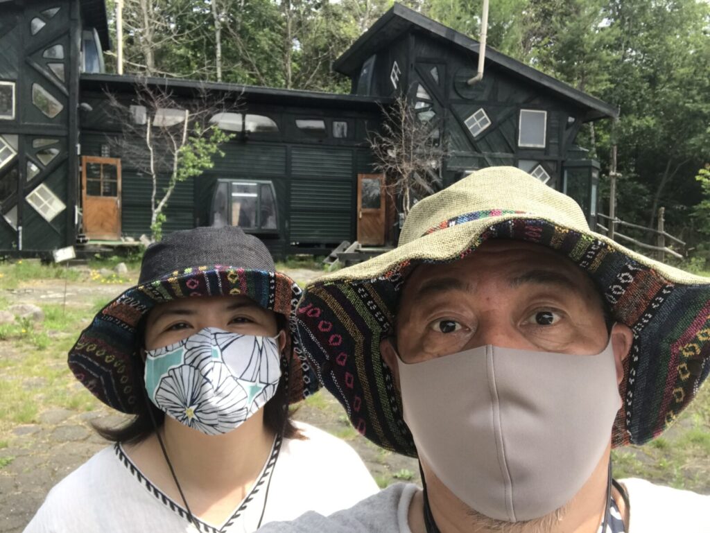 「拾って来た家」の前で撮影したマスク姿の夫婦のセルフィー写真