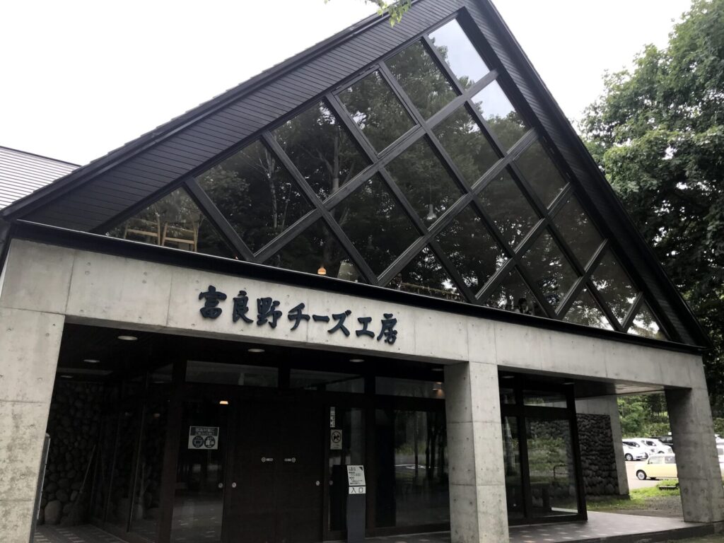 富良野チーズ工房の外観、三角屋根と大きなガラス窓が特徴的な建物