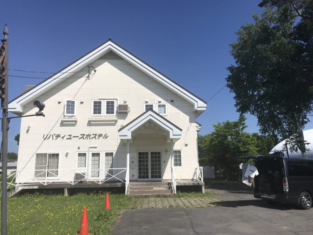 リバティユースホステルの建物全景と洗濯物を干す車