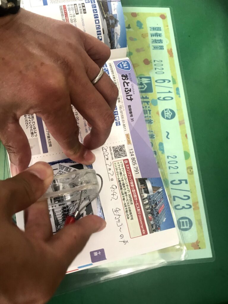 道の駅おとふけのスタンプを帳に押す手元の様子