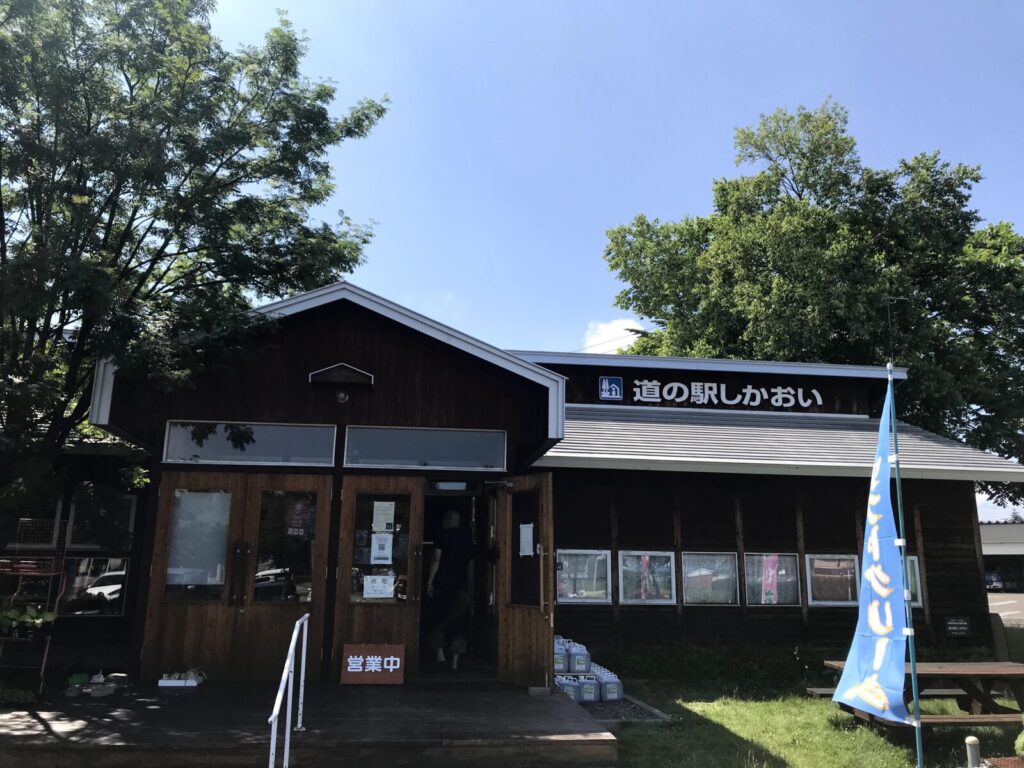 木造の落ち着いた外観の道の駅しかおい。営業中の看板が見える。