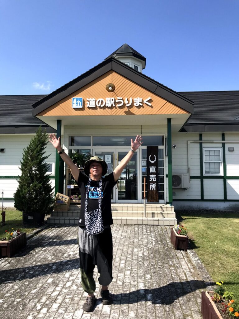 道の駅うりまく前で両手を広げてポーズをとる男性