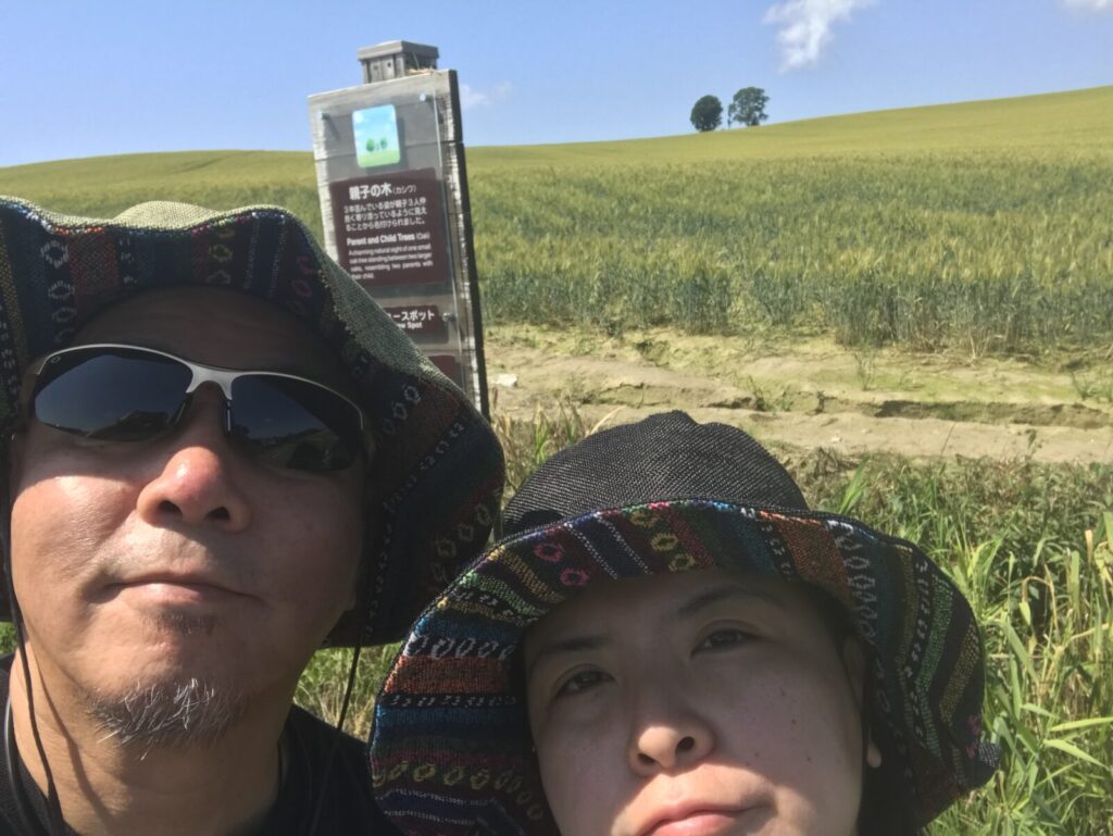 富良野の親子の木の前で自撮りをする男女