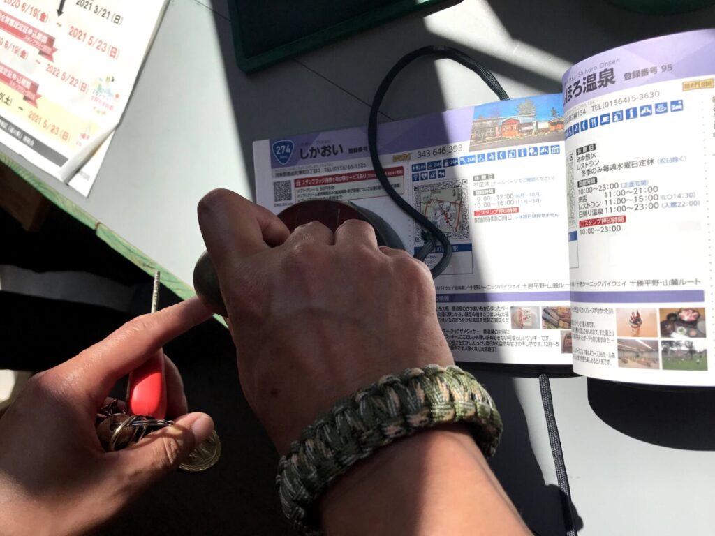 道の駅スタンプラリー帳にスタンプを押す手元の様子。