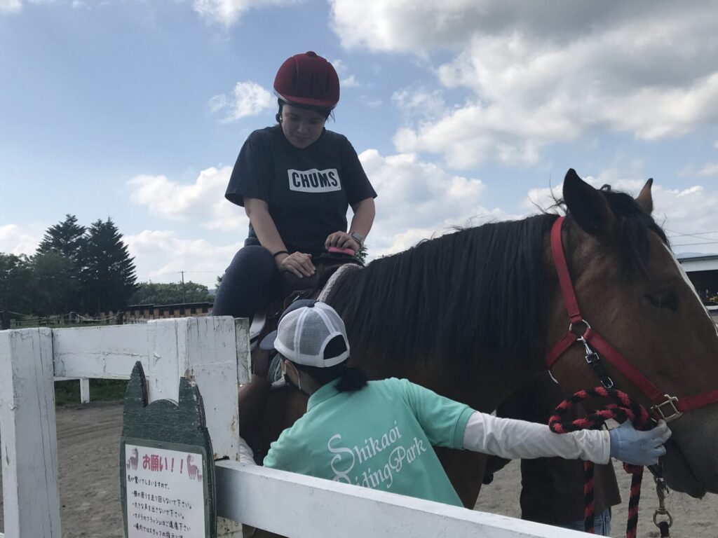 鹿追町で馬に乗る女性と補助スタッフの様子