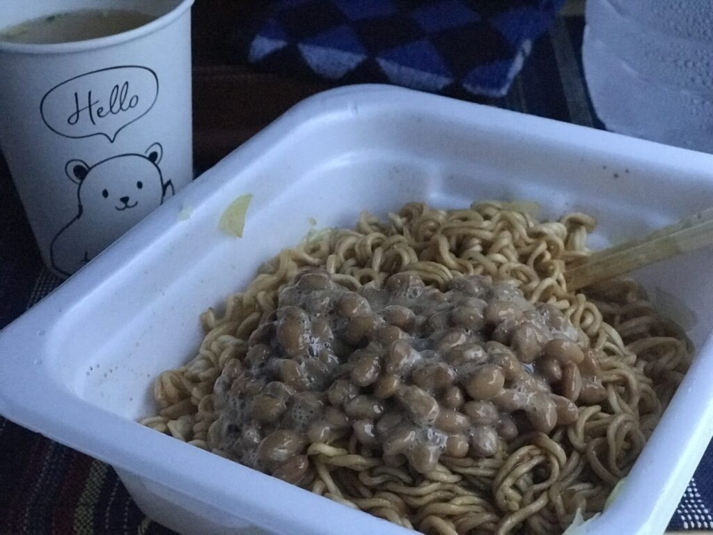 納豆をトッピングした焼きそば弁当と白くまの紙コップの食事風景