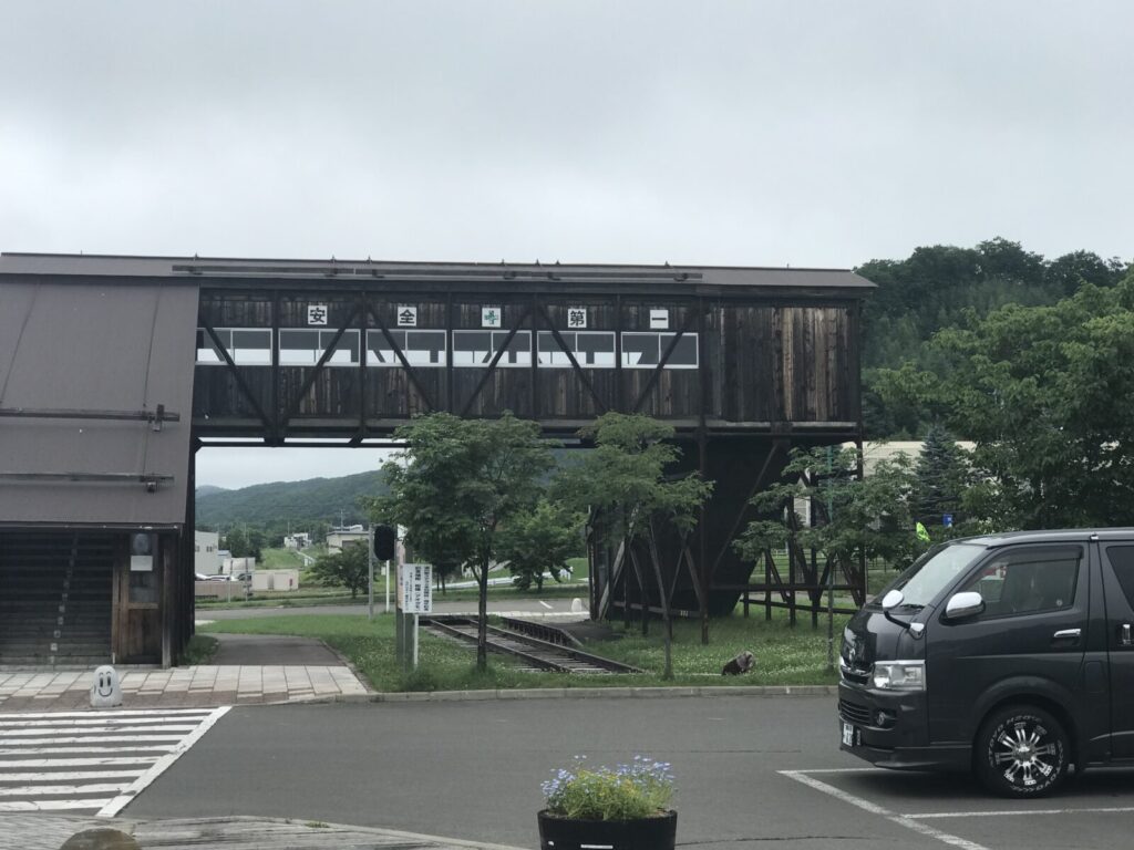 本別駅跡の木造跨線橋を駐車場側から見上げた風景、ハイエースが停車中