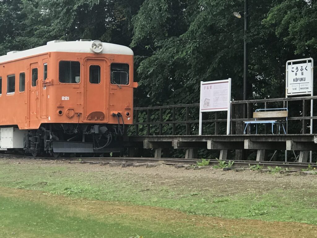 旧幸福駅のプラットフォームと停車中のオレンジ列車