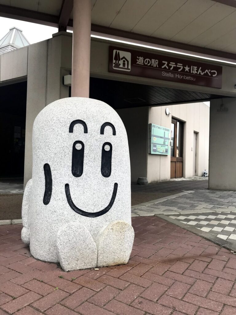 道の駅ステラ★ほんべつの入口とマスコット風の石像が並ぶ様子
