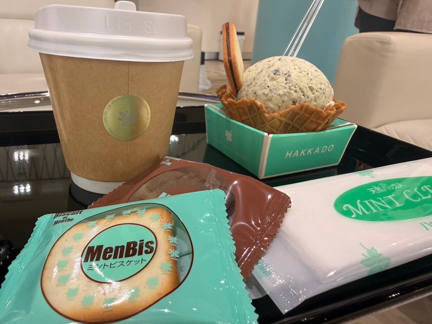 自分で購入して並べた袋入りのお菓子と、奥に写るカフェのアイス・ドリンク