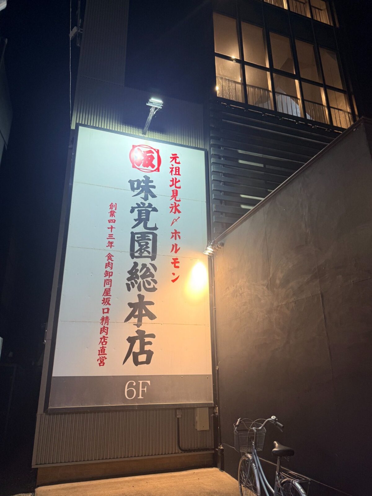 夜の建物に掲げられた味覚園 総本店6階の看板