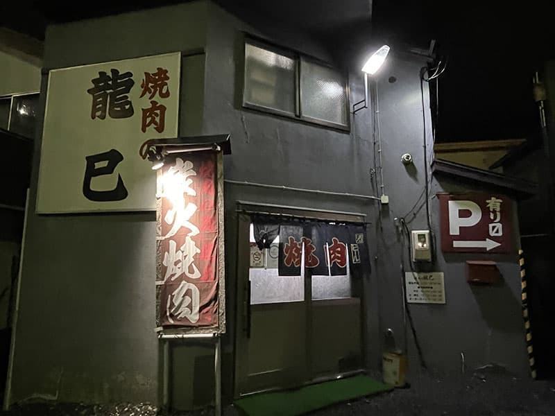 大きな龍巳の看板と暖簾が見える焼肉の龍巳の夜の入口